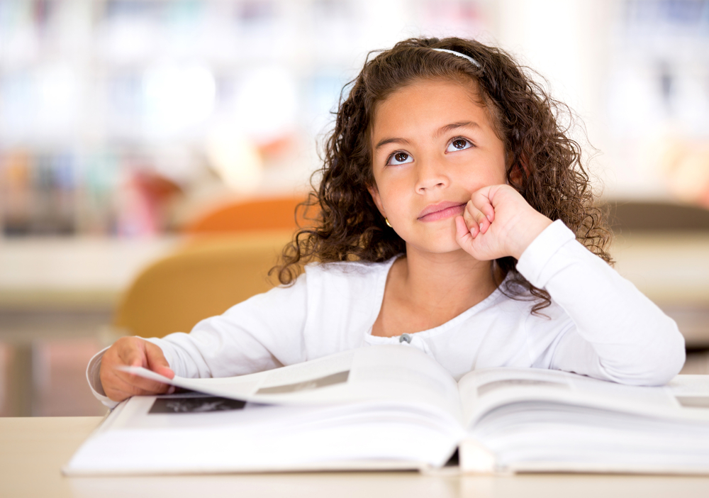 young girl reading with an inquisitive look